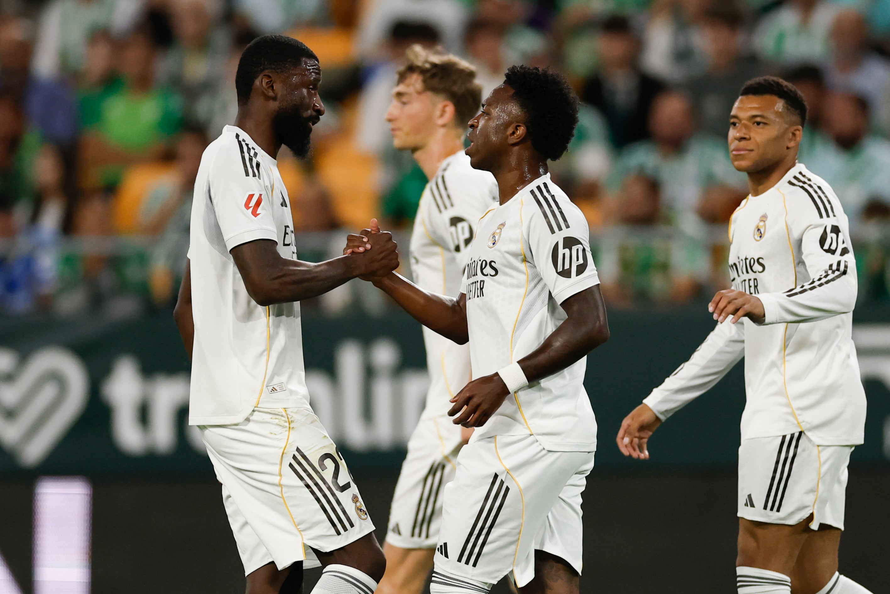 Antonio Rudiger se saluda con Vinicius.