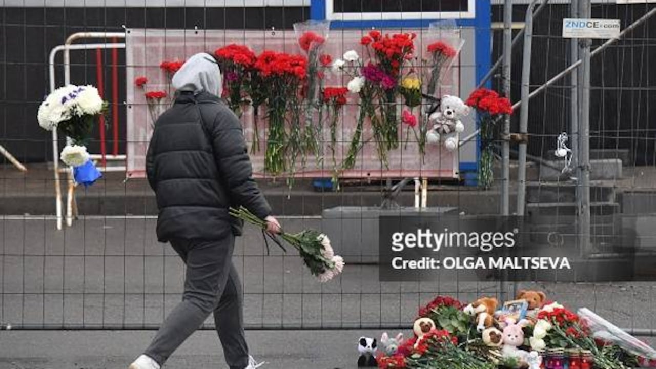 Una mujer deposita flores en un monumento improvisado frente al Ayuntamiento de Crocus, un día después de un ataque con armas de fuego en Krasnogorsk, en las afueras de Moscú, el 23 de marzo de 2024. (Photo by Olga MALTSEVA / AFP) (Photo by OLGA MALTSEVA/AFP via Getty Images)