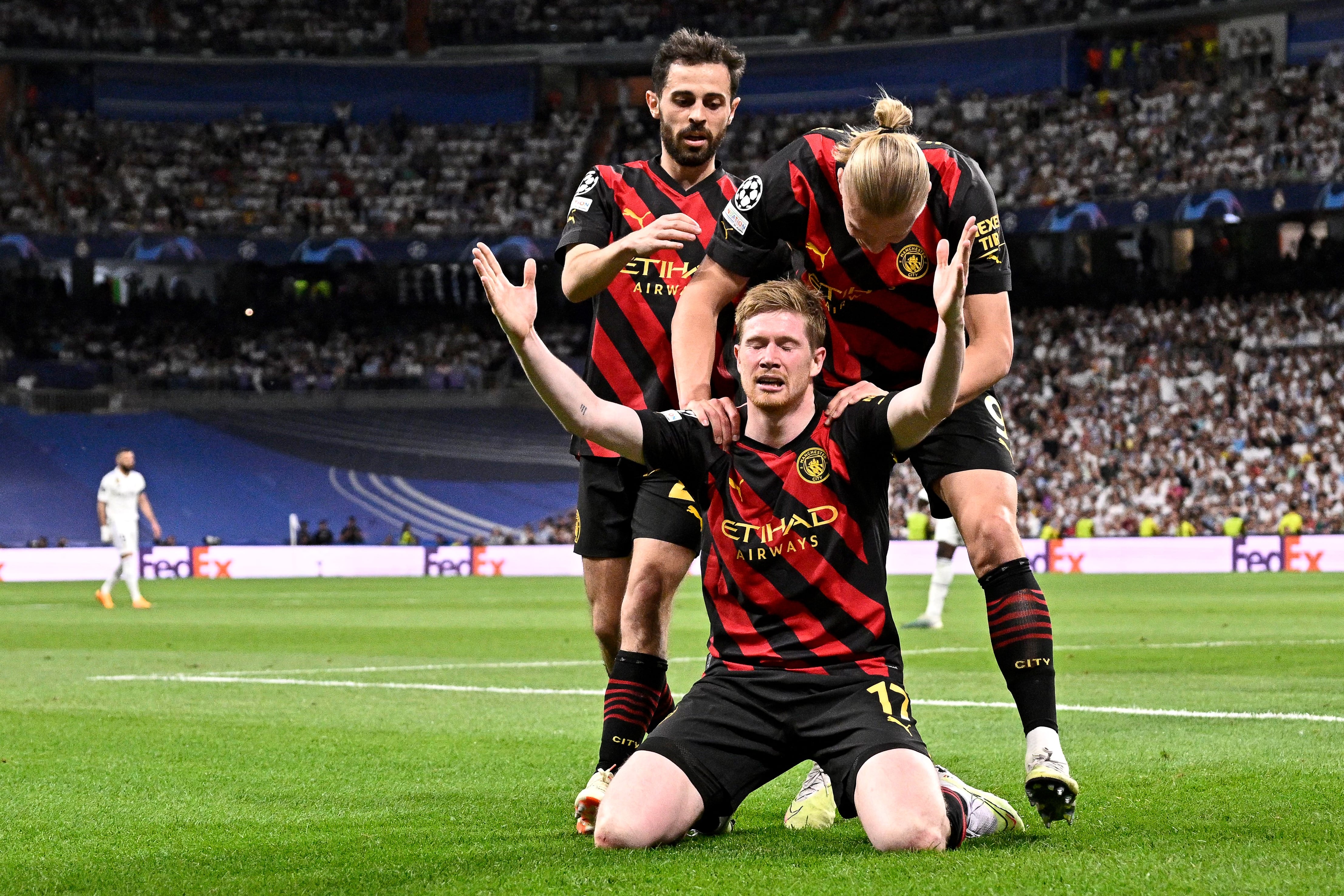 Manchester City's Belgian midfielder Kevin De Bruyne celebrates with teammates scoring his team's first goal during the UEFA Champions League semi-final first leg football match between Real Madrid CF and Manchester City at the Santiago Bernabeu stadium in Madrid on May 9, 2023. (Photo by JAVIER SORIANO / AFP)