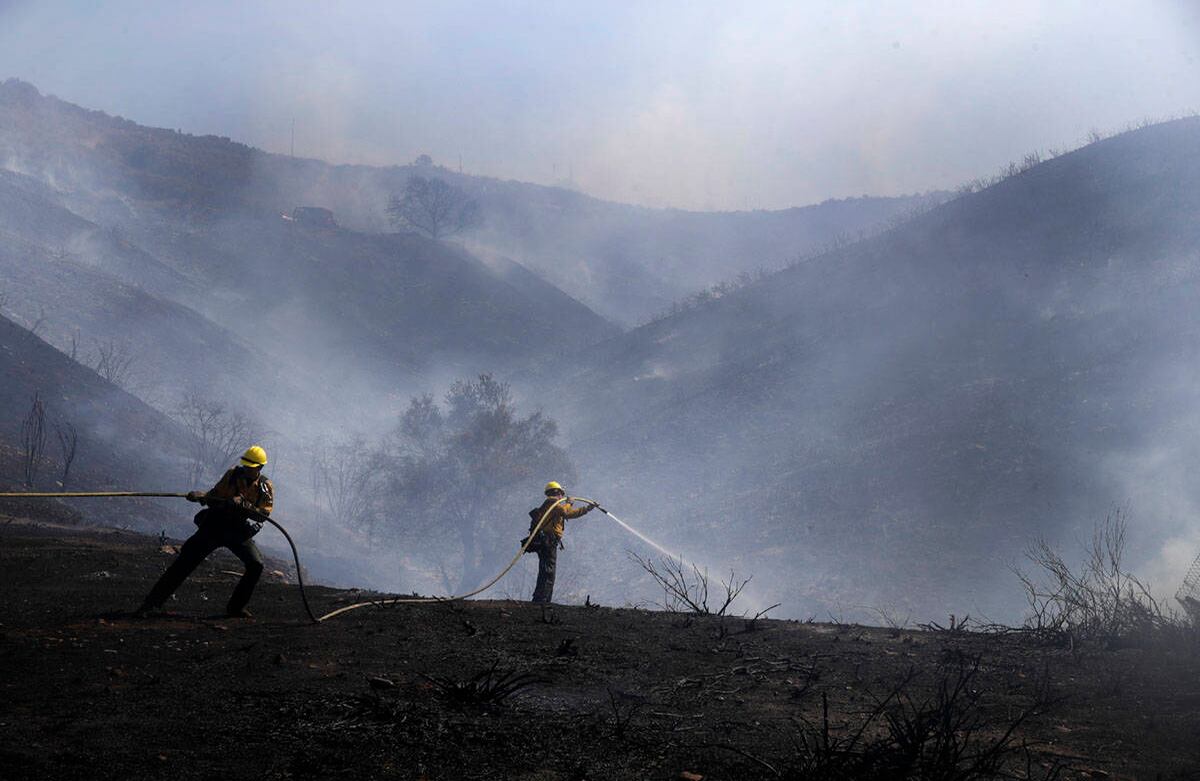 Bomberos apagan los focos del incendio de Elsmere, que se fortaleció debido a las temperaturas cálidas y secas, el lunes 3 de agosto en Santa Clarita, California. Foto: Marcio José Sánchez / AP