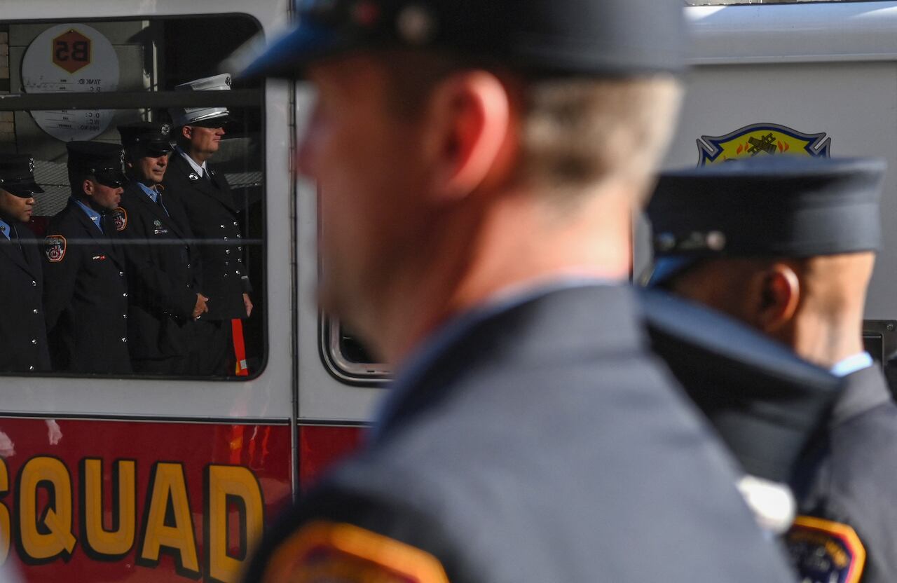 Los bomberos y otras personas participan en un momento de silencio en el vigésimo aniversario de los ataques del 11 de septiembre en el World Trade Center en Nueva York, el 11 de septiembre de 2021. - Estados Unidos celebró el vigésimo aniversario del sábado del 11 de septiembre con ceremonias solemnes. conmovedor añadido por la reciente retirada caótica de las tropas de Afganistán y el regreso al poder de los talibanes. En el memorial del 11 de septiembre en Nueva York, se guardó un momento de silencio a las 8:46 am (1246 GMT), hora en que el primer avión secuestrado se estrelló contra el World Trade Center el 11 de septiembre de 2001 (Foto de ANGELA WEISS / AFP). )