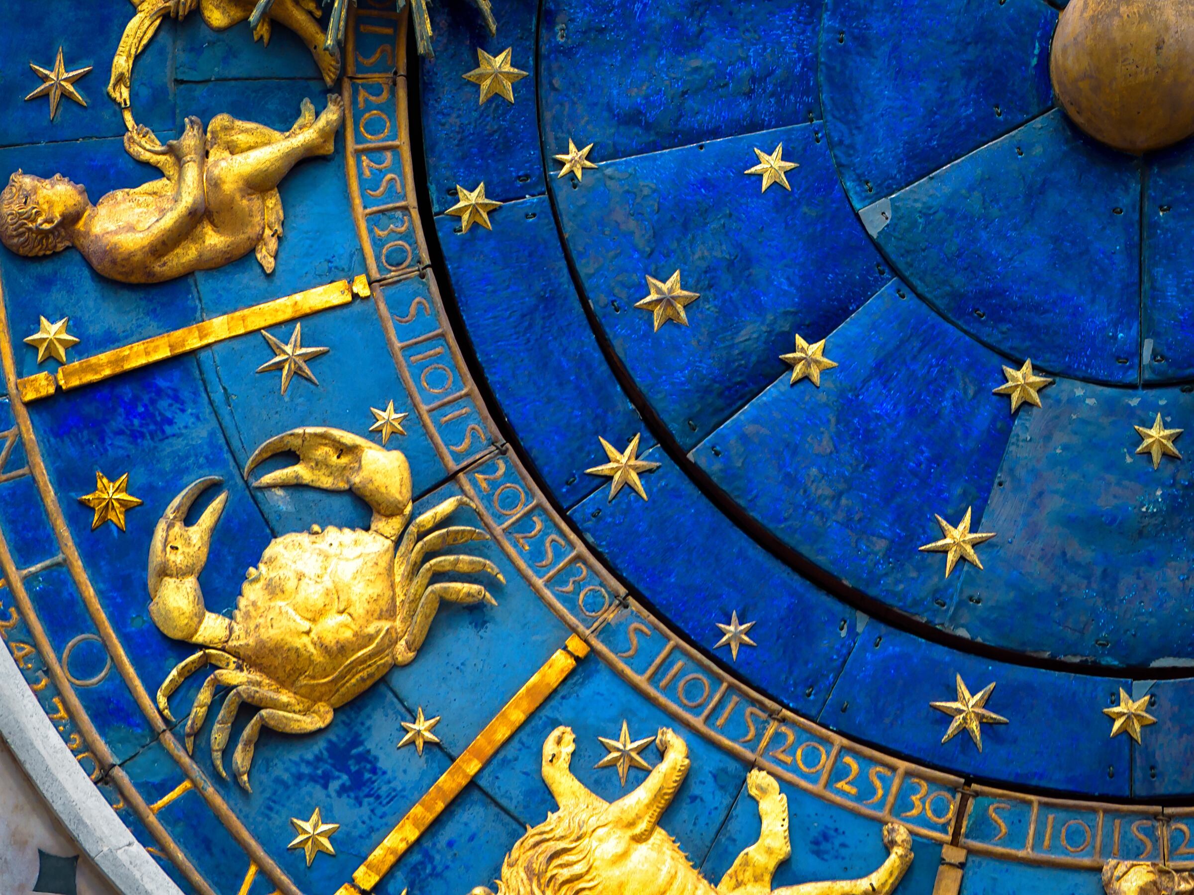 Cancer astrological sign on ancient clock, medieval Torre dell’Orologio in Venice. Detail of Zodiac wheel with crab. Golden symbol of Cancer on star circle closeup. Concept of astrology and horoscope.
