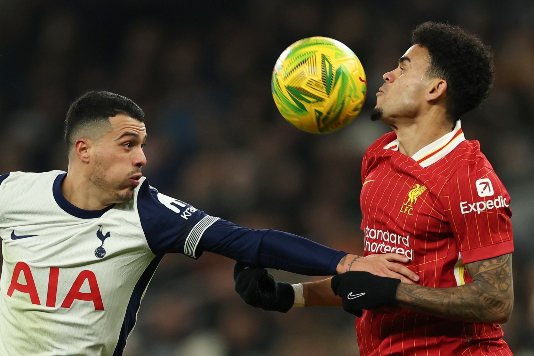 Tottenham's Pedro Porro, left, duels for the ball with Liverpool's Luis Diaz during the English League Cup semi final first leg soccer match between Tottenham and Liverpool, at the Tottenham Hotspur Stadium in London, Wednesday, Jan. 8, 2025. (AP Photo/Ian Walton)