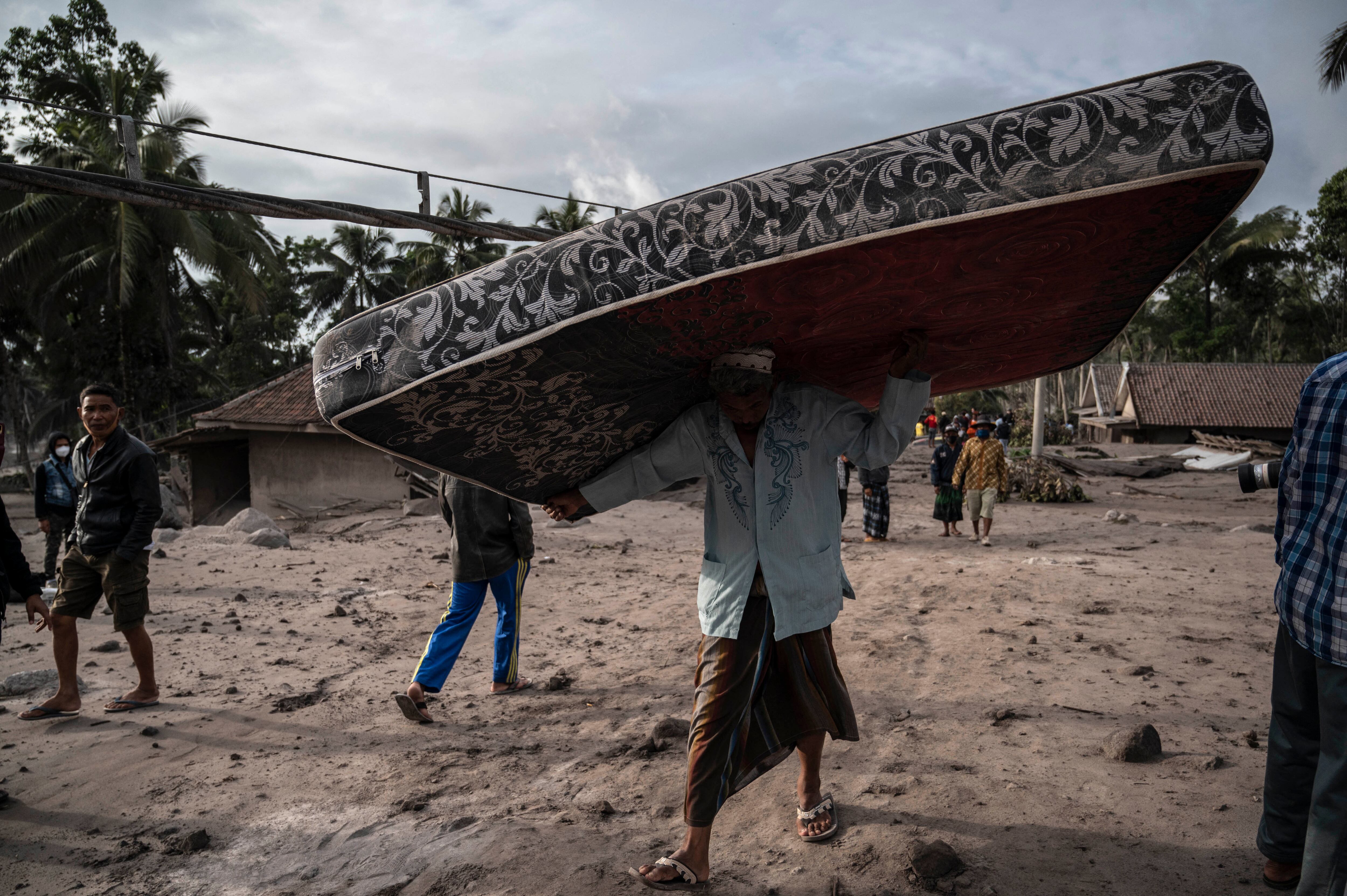 Los aldeanos rescatan sus pertenencias en un área cubierta de ceniza volcánica en la aldea de Sumber Wuluh en Lumajang el 5 de diciembre de 2021