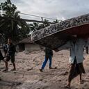 Los aldeanos rescatan sus pertenencias en un área cubierta de ceniza volcánica en la aldea de Sumber Wuluh en Lumajang el 5 de diciembre de 2021 (Photo by JUNI KRISWANTO / AFP)