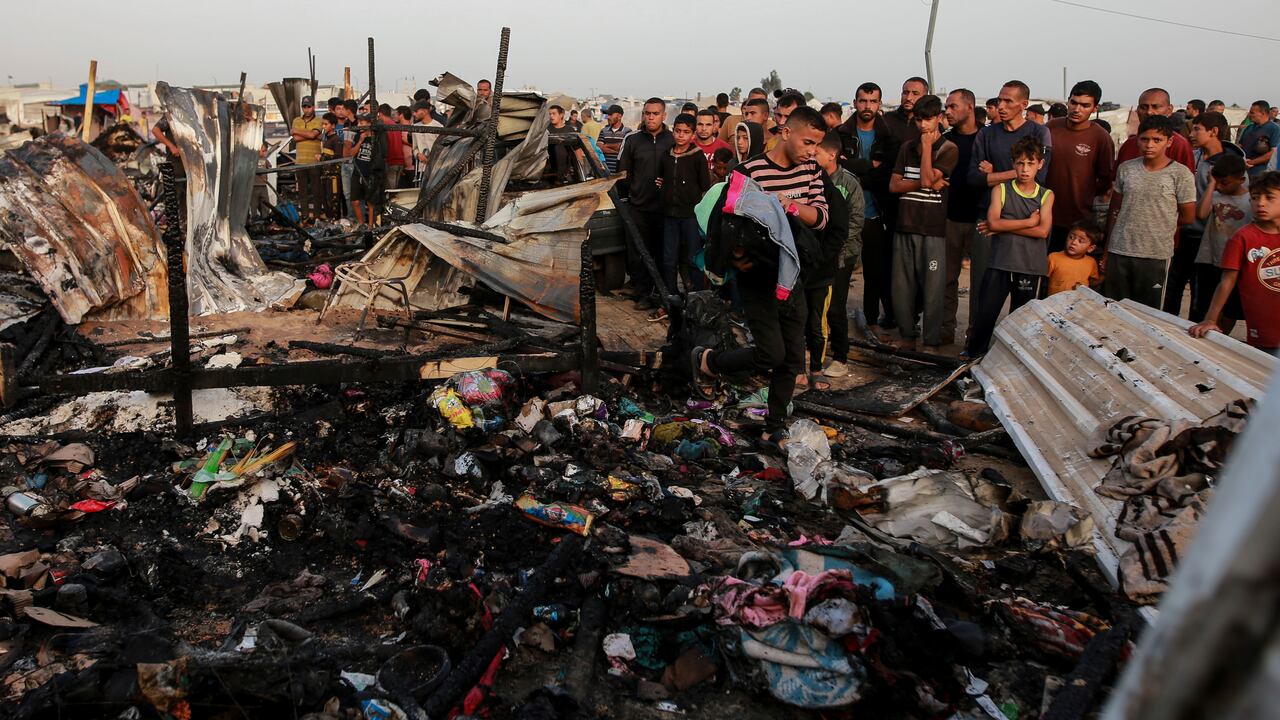 Los palestinos observan la destrucción después de un ataque israelí donde se alojaban personas desplazadas en Rafah, Franja de Gaza, el lunes 27 de mayo de 2024.