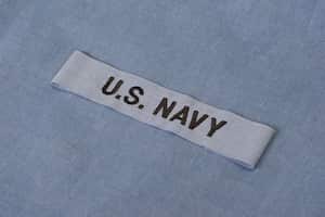 US NAVY branch tape on navy blue uniform background