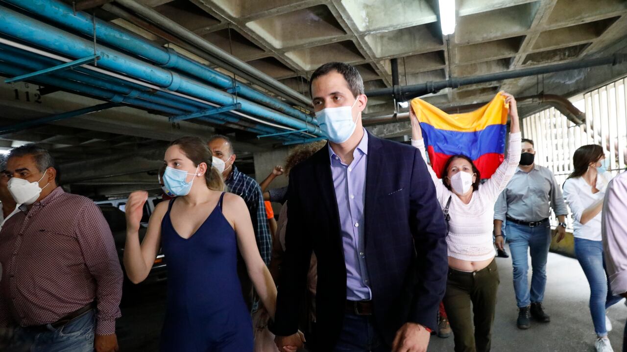 El líder opositor Juan Guaidó y su esposa, Fabiana Rosales, caminan en el estacionamiento del edificio residencial en el que viven luego de que encapuchados intentaran retener al opositor, el lunes 12 de julio de 2021. (AP Foto/Ariana Cubillos)