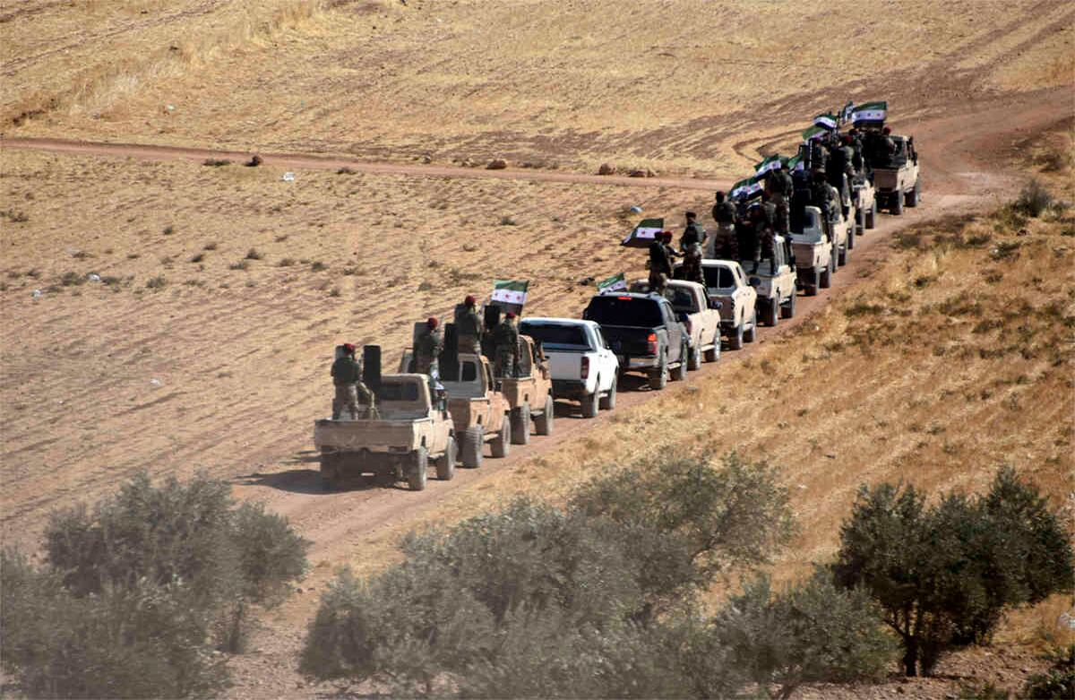 Combatientes de la FSA, respaldados por Turquía, se dirigen hacia la ciudad siria de Tal Abyad desde la ciudad fronteriza turca de Akcakale, en Turquía, el jueves 10 de octubre de 2019.  (DHA a través de AP)
