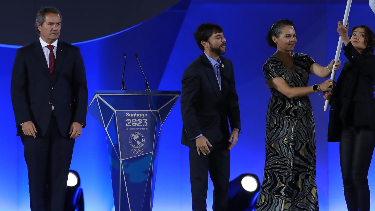 Neven Ilic, presidente de Panam Sports, entregando la bandera olímpica a Jaime Pumarejo, exalcalde de Barranquilla, y Astrid Rodríguez, Ministra del Deporte