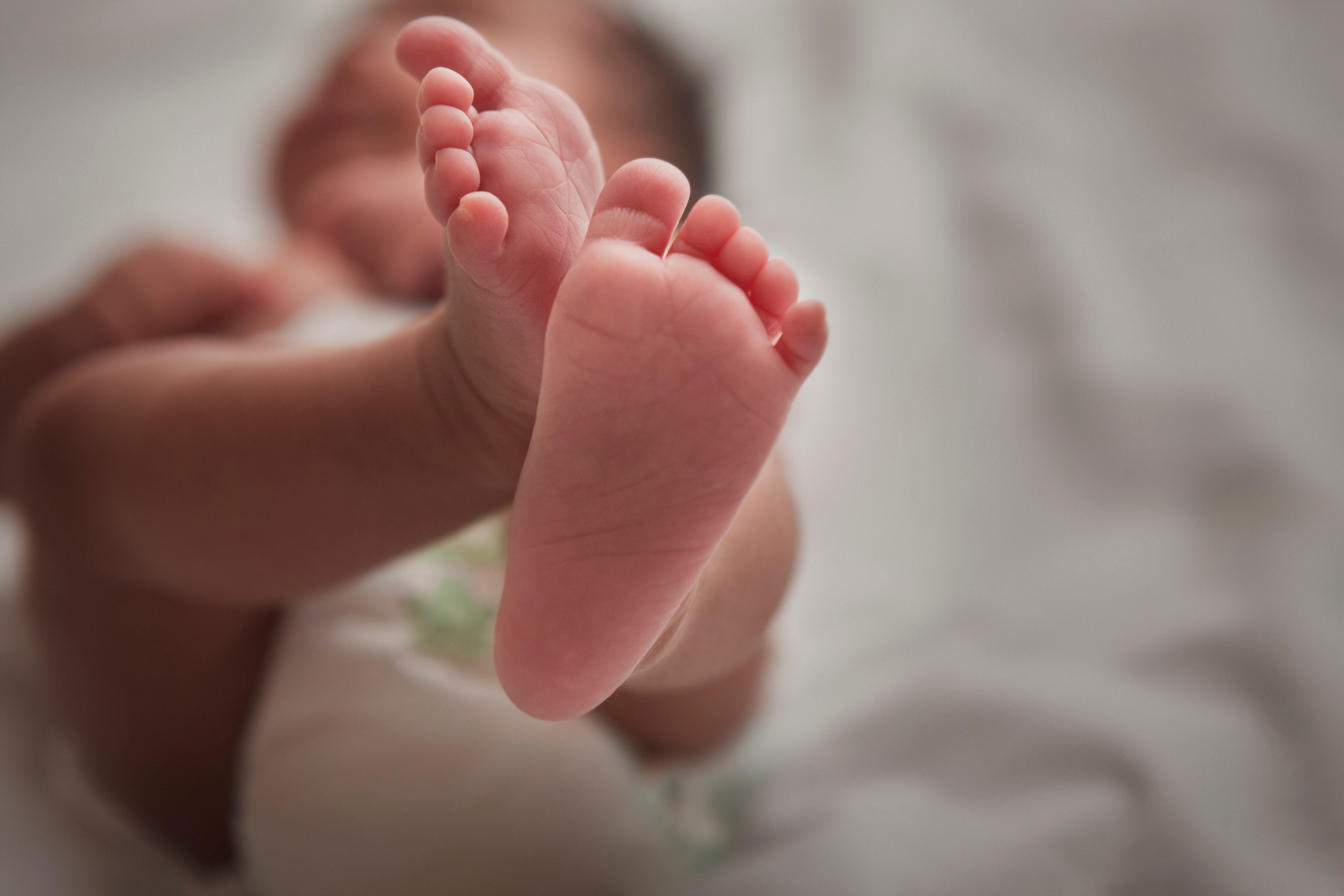 Close up of mixed race newborn baby girl's feet