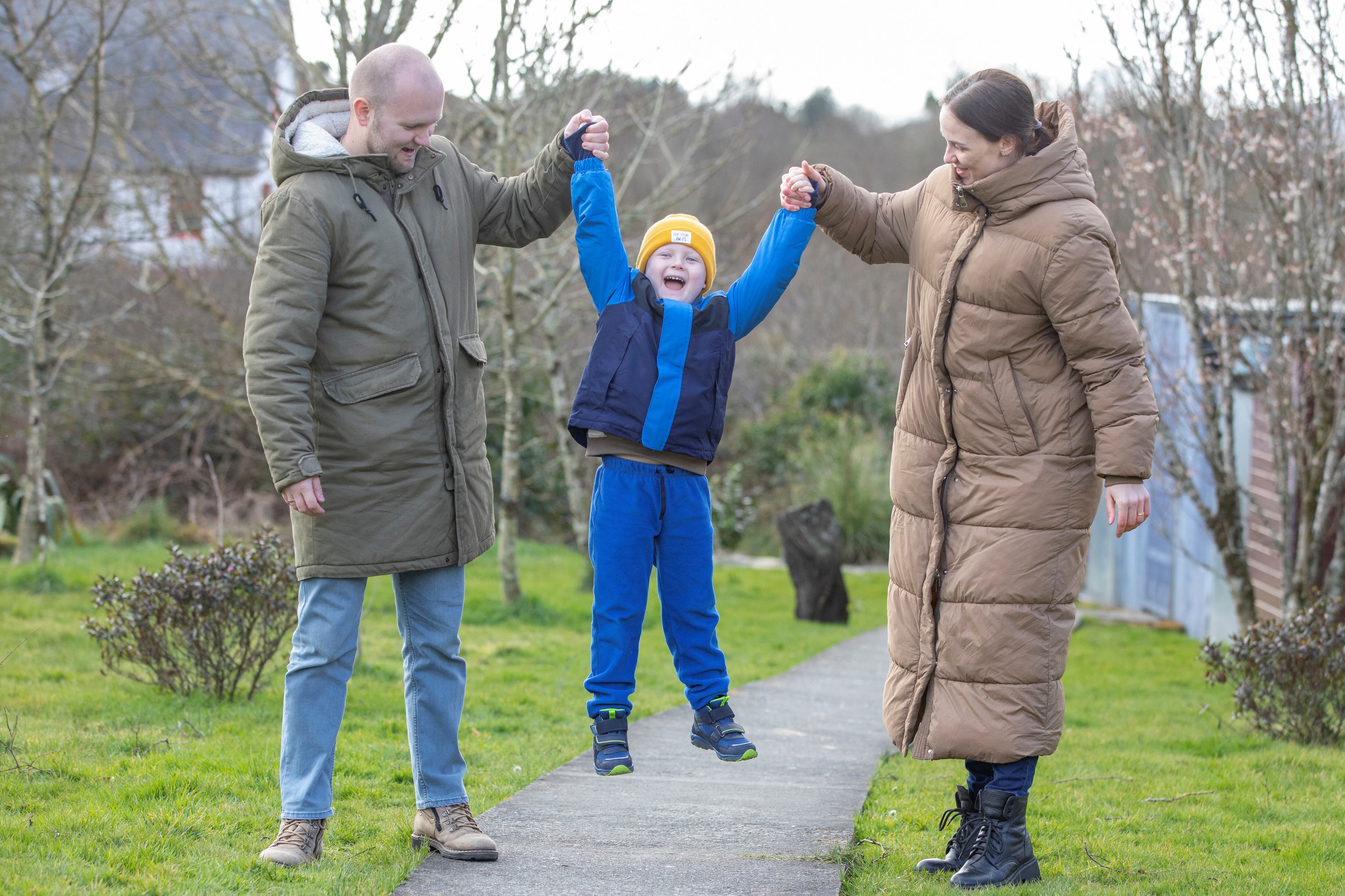 Yana (R) and Serhiy Shapoval (L) play with their five-year-old son Leonid, who suffers from leukaemia, in their new home in Ballydehob, near Cork, south west Ireland, on March 7, 2022 after fleeing Ukraine following Russia's invasion of the country. - The Shapovals escaped the war in Ukraine after doctors urged the parents of Leonid to leave the country on March 3, 2022, telling them there was no more they could do for their son. Yana and Serhiy have since learnt that the hospital, where Leonid received his chemotherapy in Kyiv, has been bombed by Russian forces. Five-year-old Leonid is now being treated in Ireland for his condition. (Photo by PAUL FAITH / AFP)