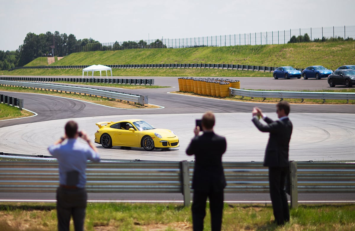 Un piloto corre mientras los asistentes lo observan durante la inauguración de la sede norte americana del Centro de Experiencia Porsche, en Atlanta, Estados Unidos. (AP/David Goldman)
