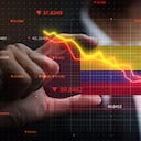 Gráfico cayendo frente a la bandera de Colombia. Concepto de crisis