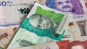 Dinero colombiano, pesos colombianos esparcidos sobre la mesa, billetes de papel