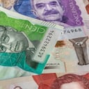 Dinero colombiano, pesos colombianos esparcidos sobre la mesa, billetes de papel