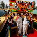 Los médicos con trajes protectores piden que la siguiente persona en la fila aborde una trajinera para la prueba de COVID-19 en el distrito de Xochimilco de la Ciudad de México, el jueves 10 de septiembre de 2020. (AP Photo / Rebecca Blackwell).