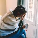 Mujer con temperatura quedarse en casa envuelto en bufanda y beber té caliente