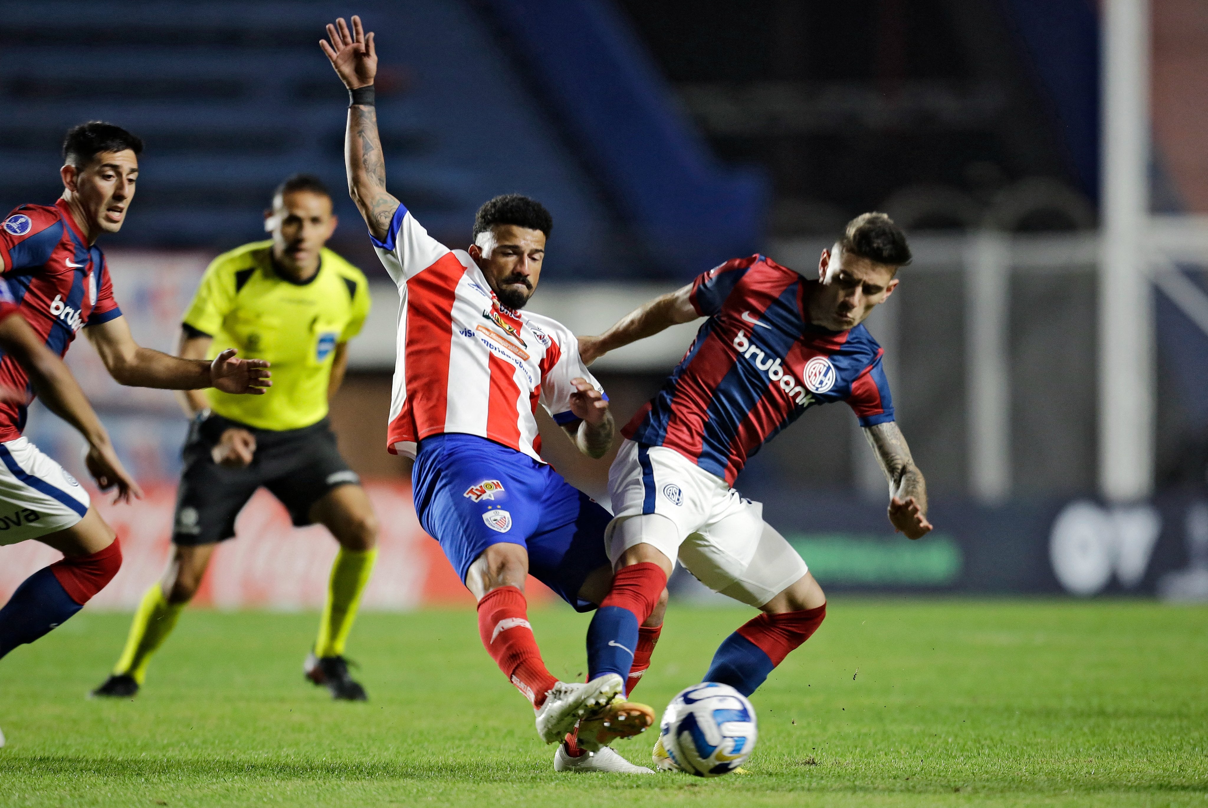 Jugador de San Lorenzo disputa el balón en un partido por Copa Sudamericana
