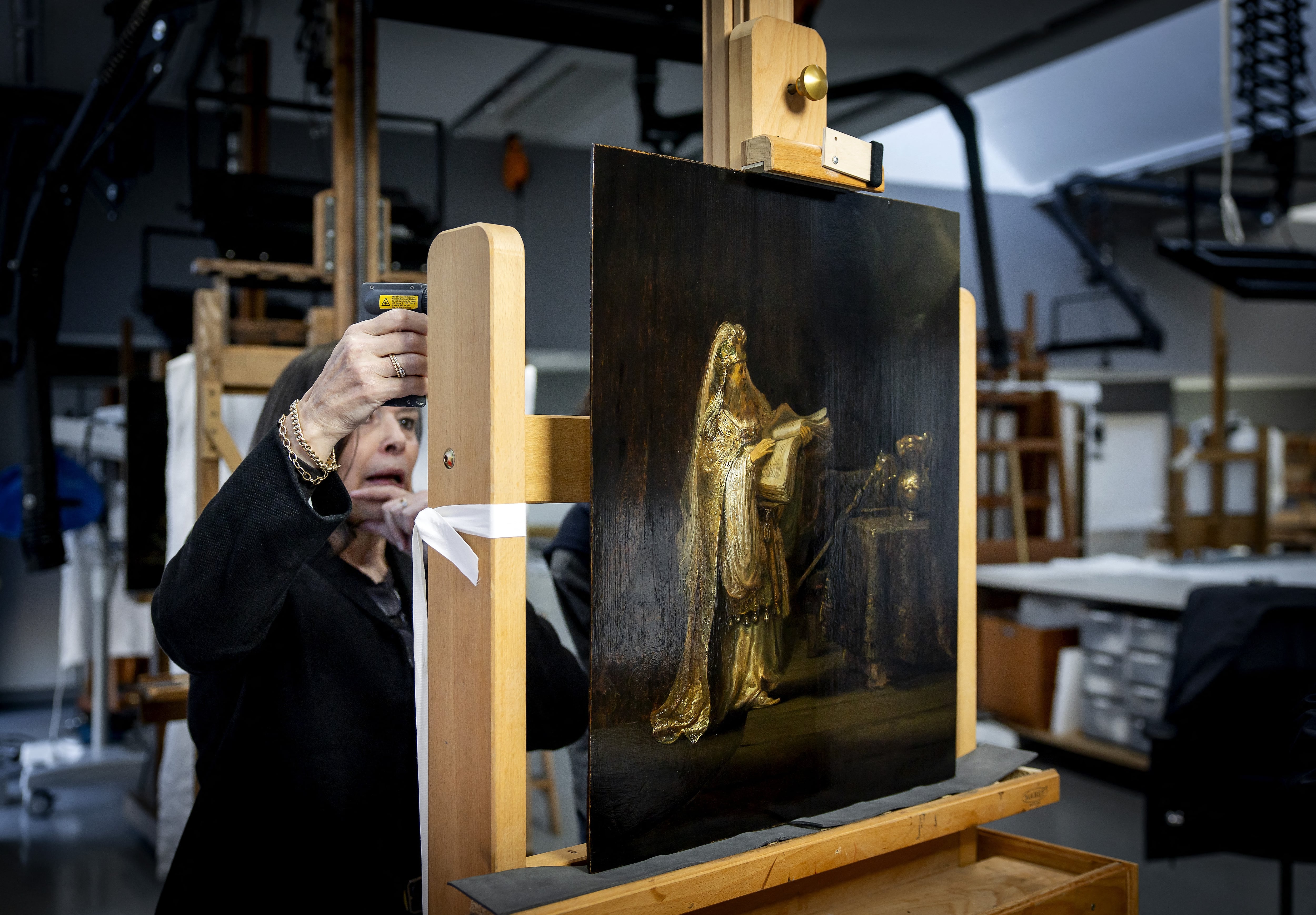 Un investigador observa la obra recién descubierta del pintor holandés Rembrandt van Rijn, titulada "La visión de Zacarías en el Templo", en el estudio del Rijksmuseum de Ámsterdam el 2 de marzo de 2026. Foto: Koen van Weel / ANP / AFP.