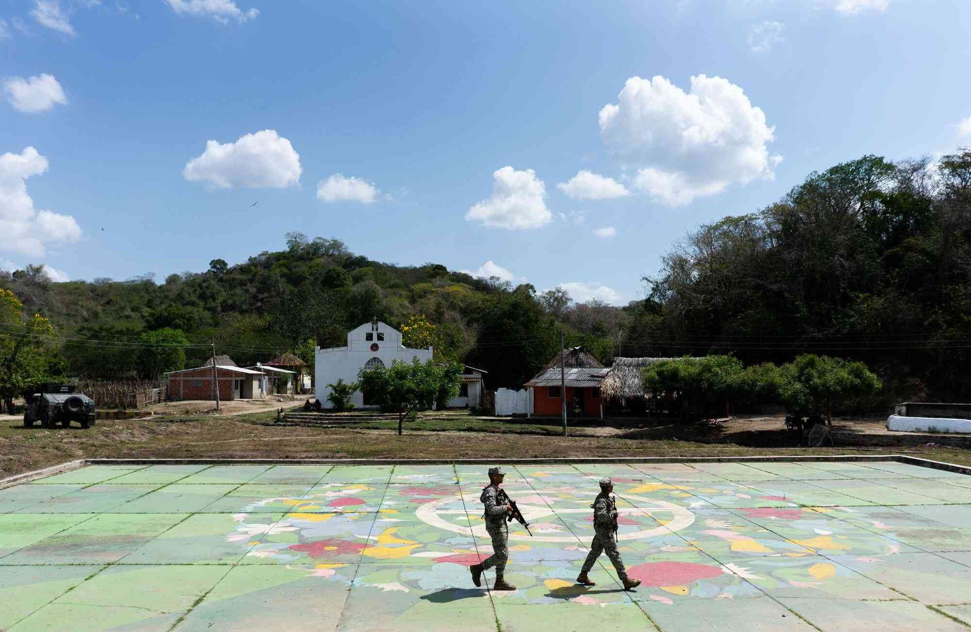 Infantes de Marina enviados desde Cartagena caminan sobre la recordada cancha central del pueblo donde hace 19 años las AUC perpetraron una de las masacres mas sangrientas y dolorosas del país.