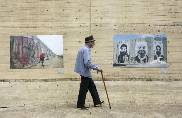  Un señor camina entre dos fotografías de una muestra sobre fronteras, el tema central de la Fiesta del Libro y la Cultura 2014.