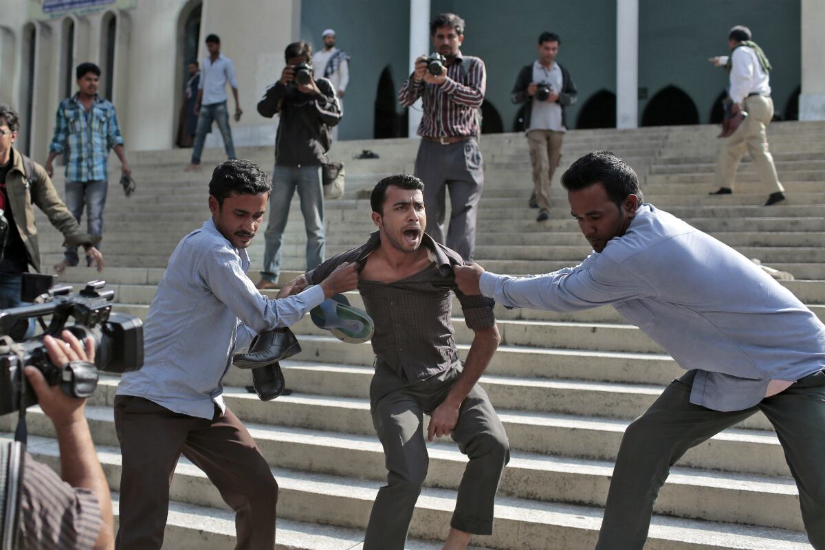 Los activistas del partido Liga Awami de Bangladés, el mayoritario del Gobierno, tratan de batir a un manifestante, el del centro de la imagen, fuera de la Mezquita Nacional de Bangladés, durante una protesta en Dacca, Bangladés. La manifestación era en contra del primer ministro bangladesí y líder del partido Liga Awami, Sheikh Hasina, tambien contra el ministro de telecomuncaciones, Abdul Latif Siddique, luego de sus comentarios anti-islámicos en un rally. (AP)