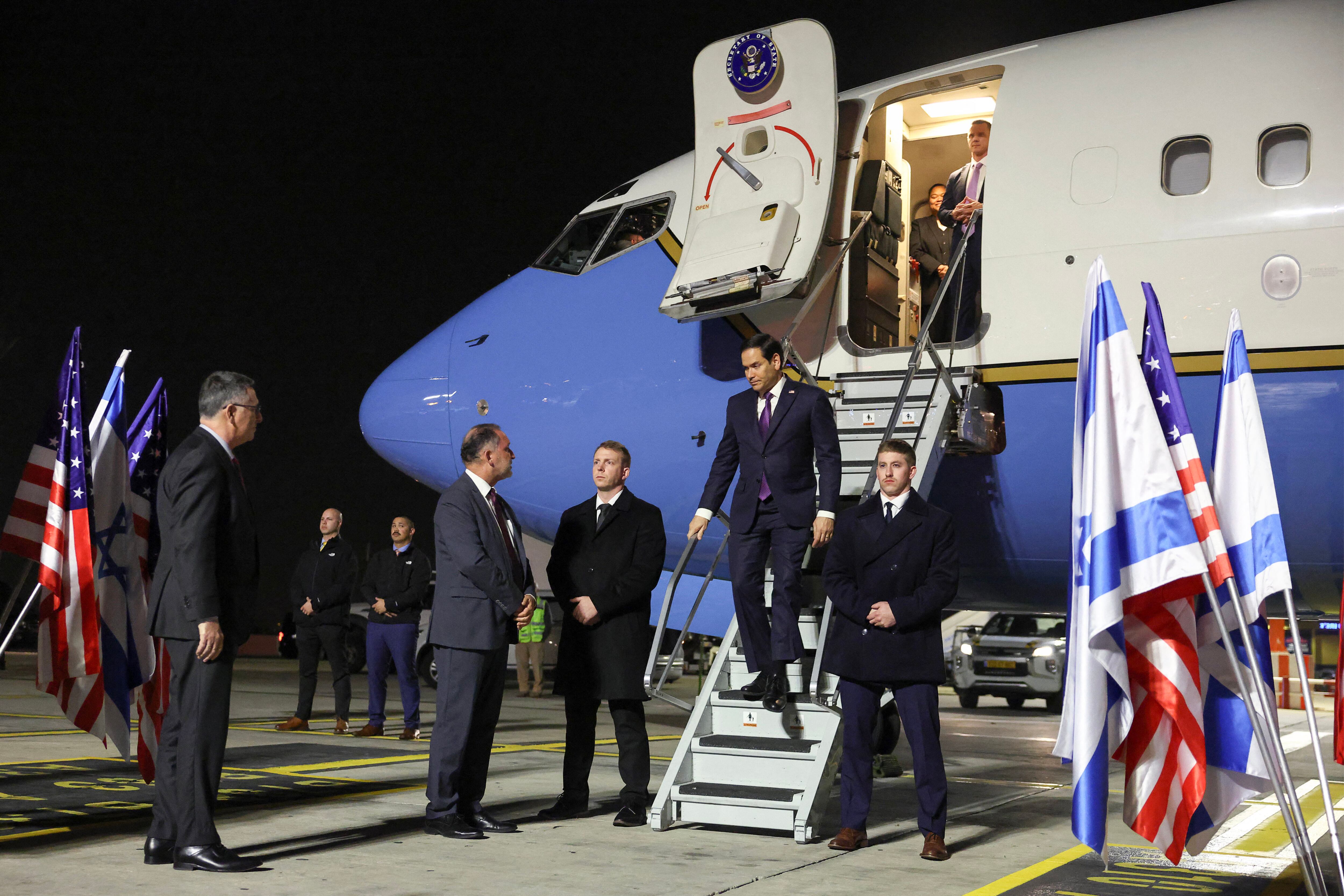 El ministro de Relaciones Exteriores de Israel, Gideon Saar (izquierda), observa mientras el secretario de Estado de los Estados Unidos, Marco Rubio, desciende de su avión a su llegada al aeropuerto Ben Gurion de Israel, en Lod, el 15 de febrero de 2025, en la primera etapa de su viaje por el Medio Oriente. (Foto de Evelyn Hockstein / POOL / AFP)