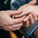Close-up of a gay's hand placing the ring on his friends hand during their gay wedding ceremony