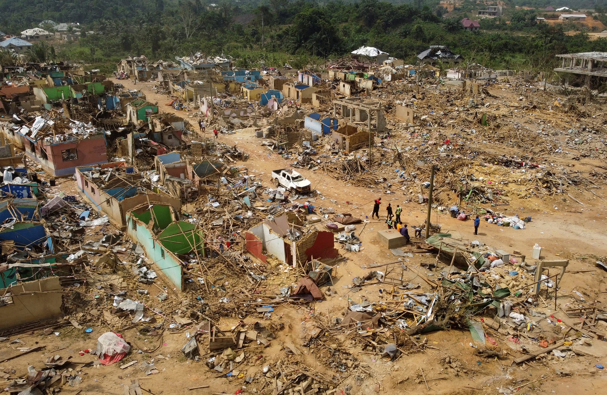 La gente observa los daños causados cuando un vehículo que transportaba explosivos mineros detonó a lo largo de una carretera en Apiate, Ghana. Foto REUTERS/Francis Kokoroko