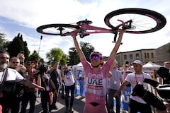 El esloveno Tadej Pogacar, vestido con la camiseta rosa del líder general de la carrera, sostiene su bicicleta mientras celebra después de ganar la vigésima etapa de la carrera ciclista Giro de Italia desde Alpago hasta Bassano del Grappa, Italia, el sábado 25 de mayo de 2024. (Fabio Ferrari/LaPresse vía AP)