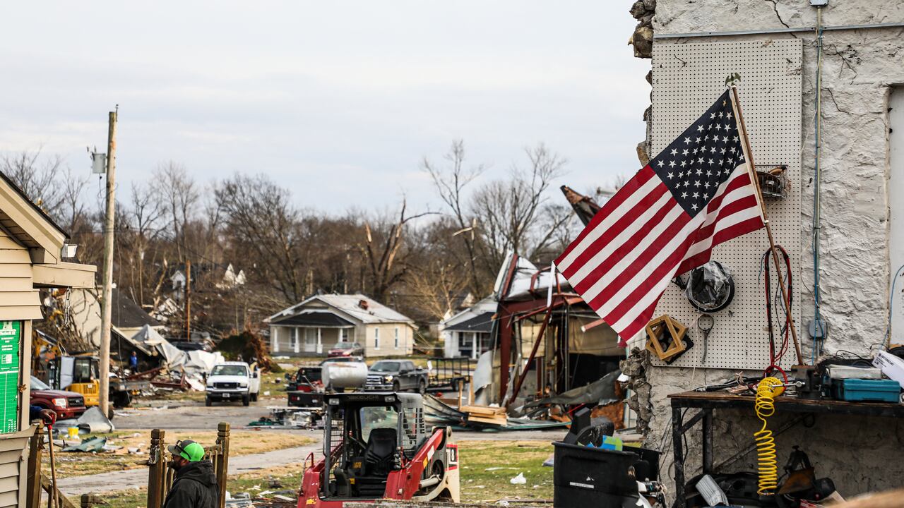 Una bandera nacional de EE. UU. Ondea entre los daños causados por un tornado después de que el clima extremo azotara la región en Bowling Green, Kentucky, el 11 de diciembre de 2021. - Docenas de tornados devastadores arrasaron cinco estados de EE. UU. Durante la noche, dejando más de 80 personas muertas el sábado en lo que el presidente Joe Biden dijo que fue "uno de los mayores" brotes de tormenta de la historia. (Foto de Gunnar Word / AFP)