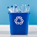Contenedor de reciclaje con botellas de agua de plástico vacías.