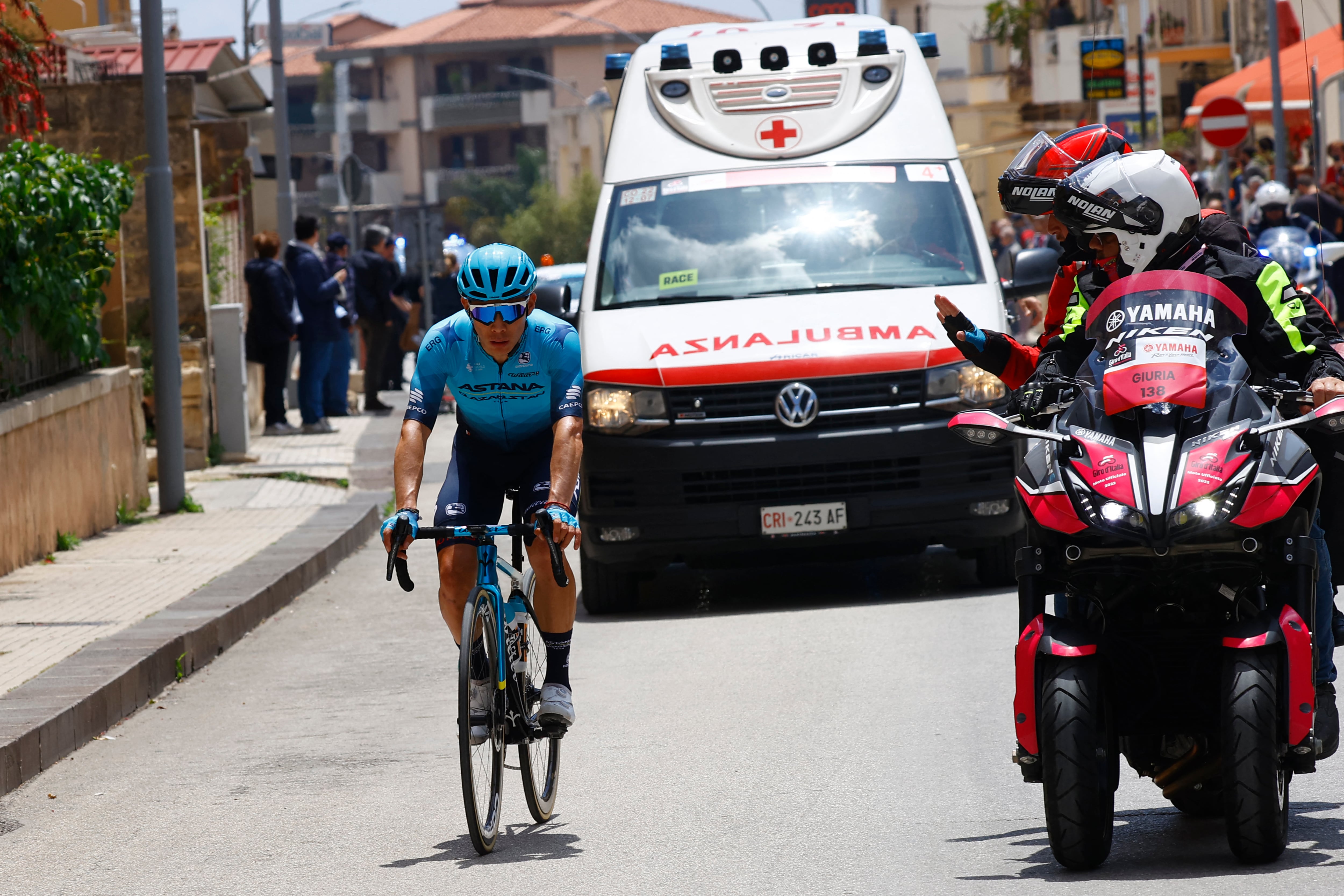 Team Astana's Colombian rider Miguel Angel Lopez rides by an Italian Red Cross ambulance in the first kilometers of the 4th stage of the Giro d'Italia 2022 cycling race, 172 kilometers between Avola and Etna-Nicolosi, Sicily, on May 10, 2022. (Photo by Luca Bettini / AFP)