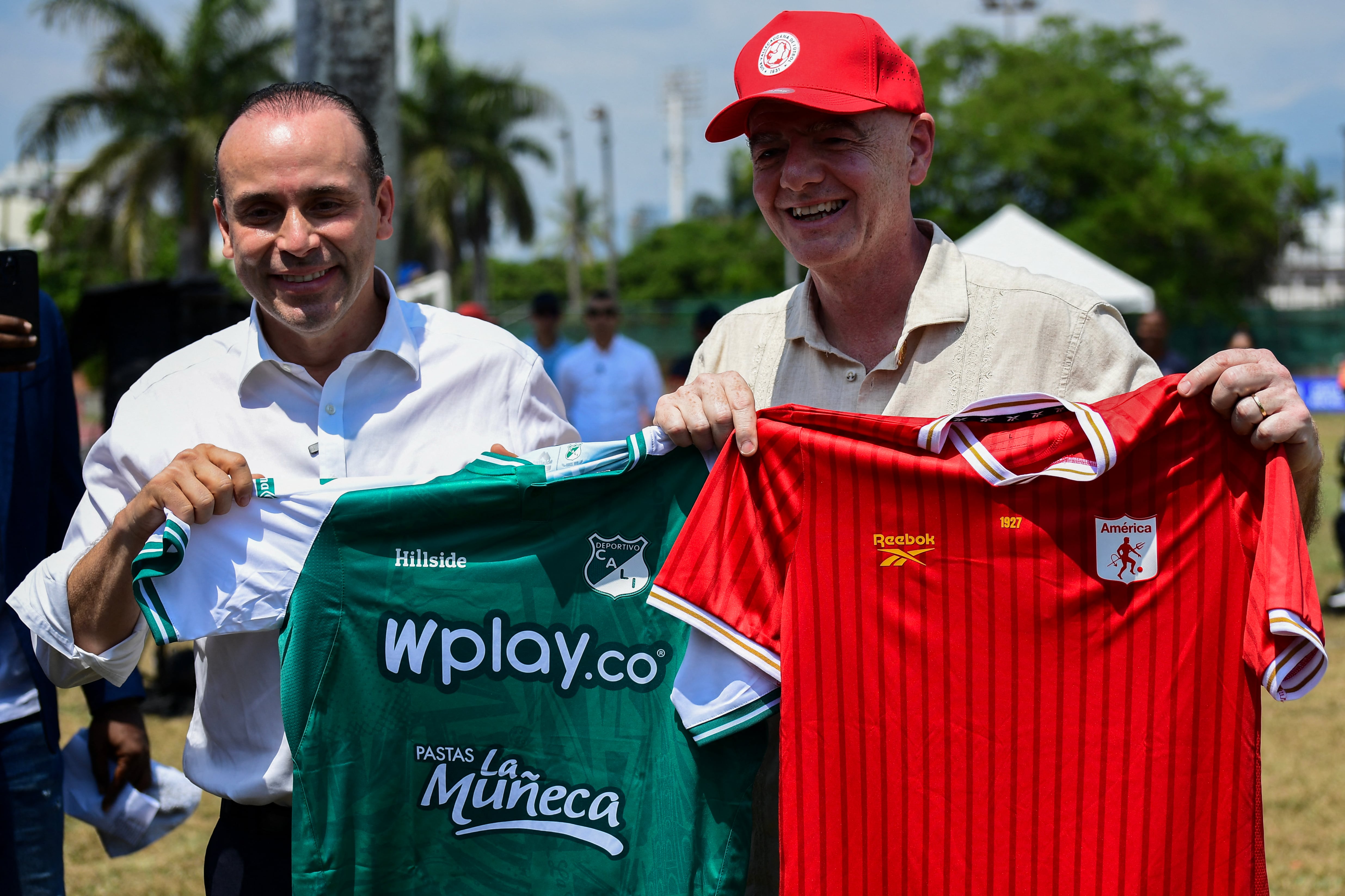 Cali's mayor Alejandro Eder presents FIFA'S president Gianni Infantino with the jerseys of Deportivo Cali (L) and America de Cali football teams during a visit to a sports complex in Cali, Colombia, on August 7, 2026. (Photo by Jaime SALDARRIAGA / AFP)