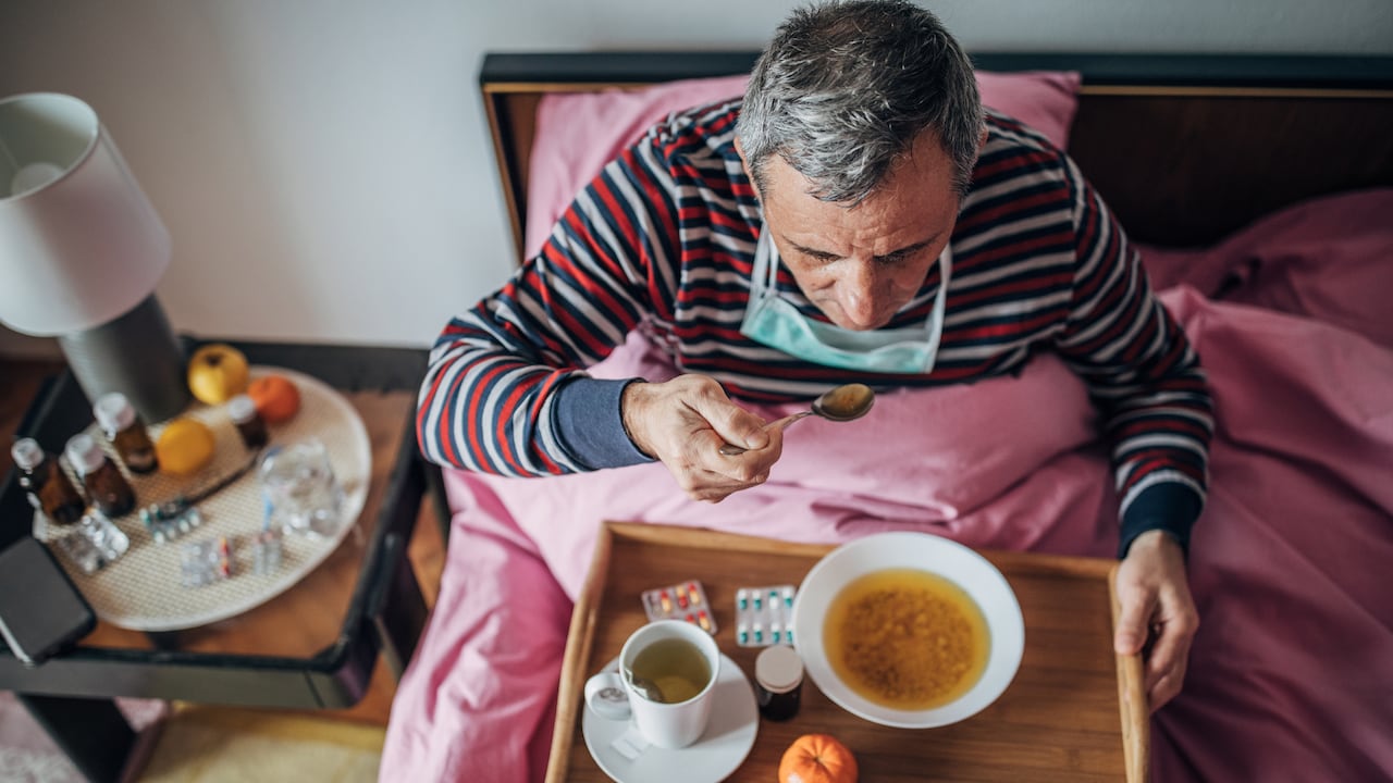 Foto de referencia sobre una persona con un tapabocas mientras come
