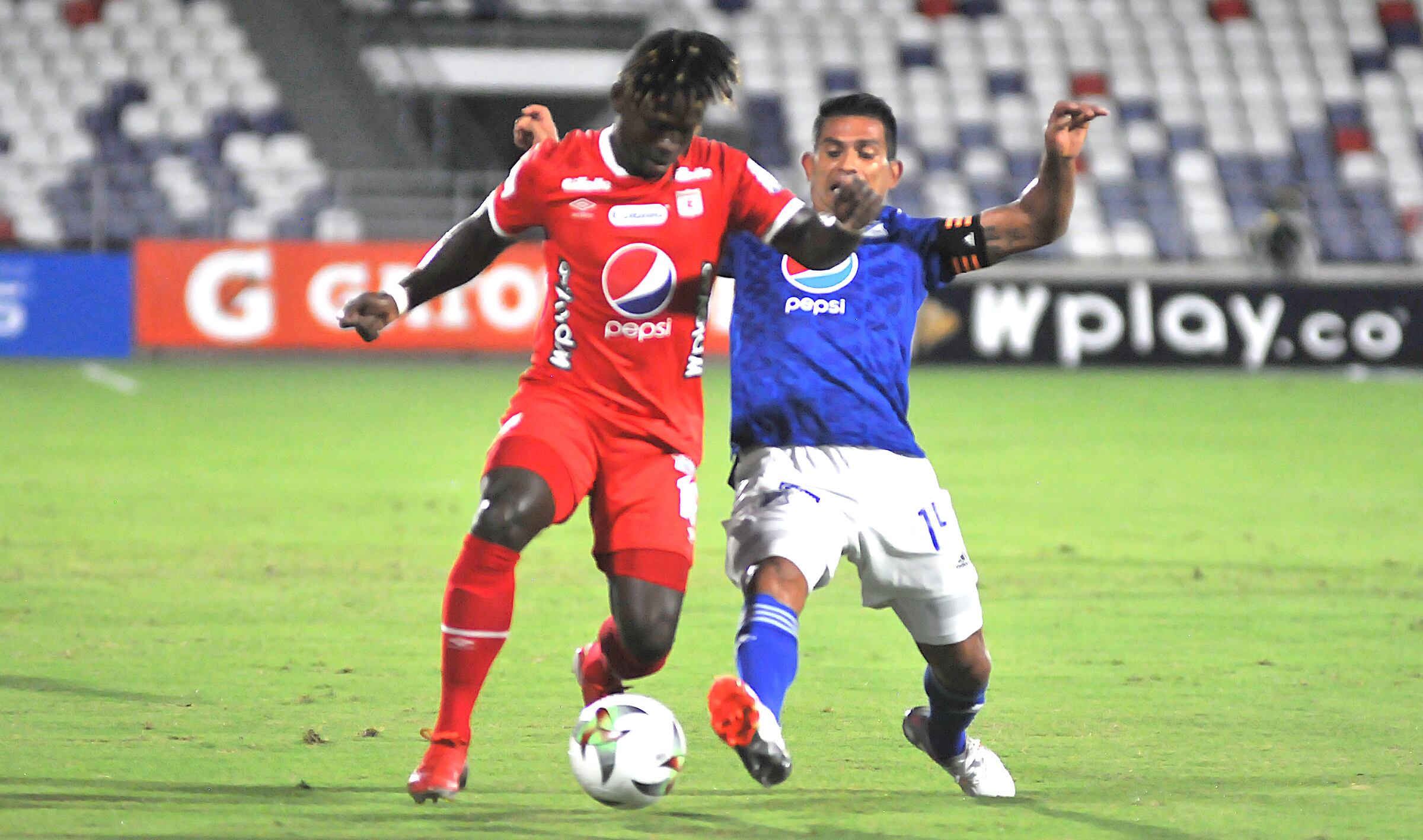 BARRANQUILLA - COLOMBIA, 28-11-2021: Deinner Quinones del América de Cali disputa el balón con David Silva de Millonarios durante partido por la fecha 21 de la clausura de los cuadrangulares  entre el América de Cali  y Millonarios  como parte de la Liga BetPlay DIMAYOR II 2021 jugado en el estadio Romelio Martínez  de la ciudad de Barranquilla./Deinner Quinones del America de Cali  disputa el balón con XXXXX de Millonarios  durante partido por la fecha 21 de la clausura de los cuadrangulares  entre el America de Cali y Millonarios  como parte de la Liga BetPlay DIMAYOR II 2021 jugado en el estadio Romelio  Martinez de la ciudad de Barranquilla. Photo: VizzorImage / Jesus Rico / Contribuidor