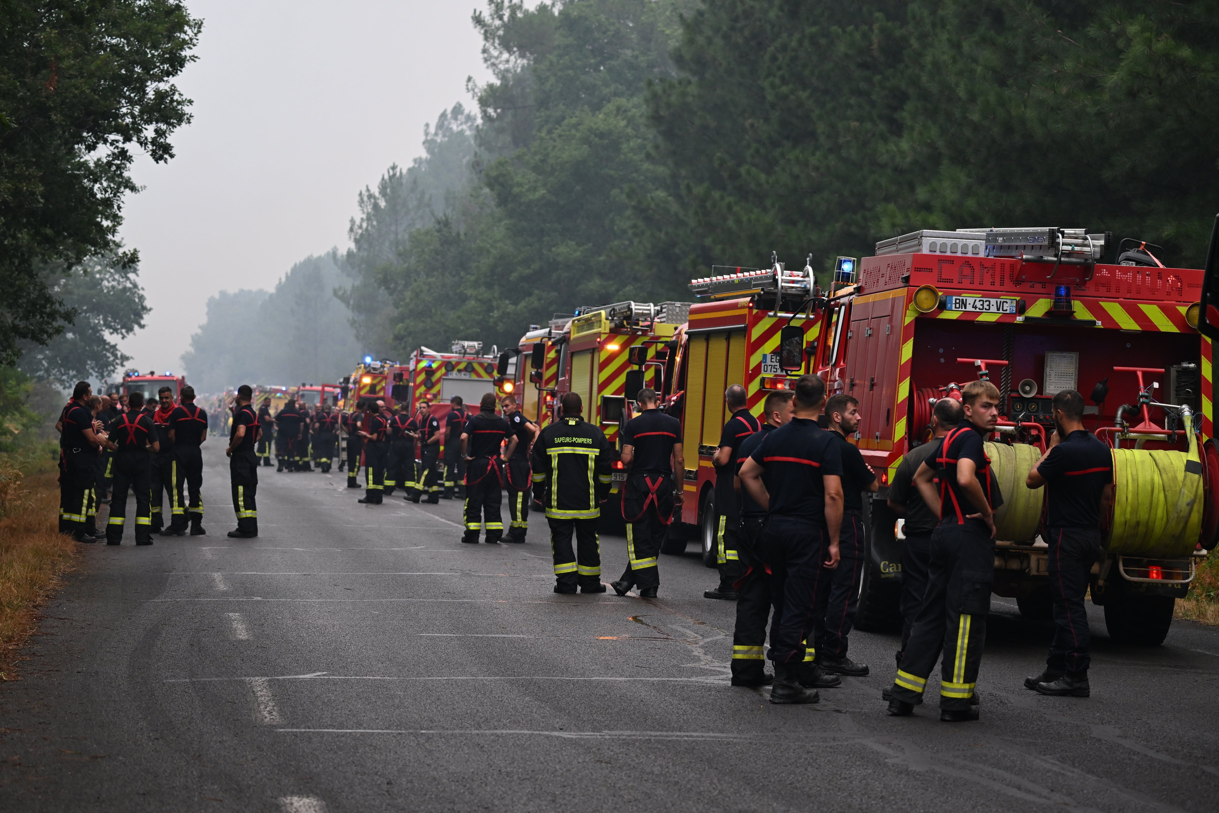 Bomberos esperan en una carretera próxima a Lacanau, en el suroeste de Francia.