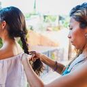 Mother braiding the hair of teenage daughter