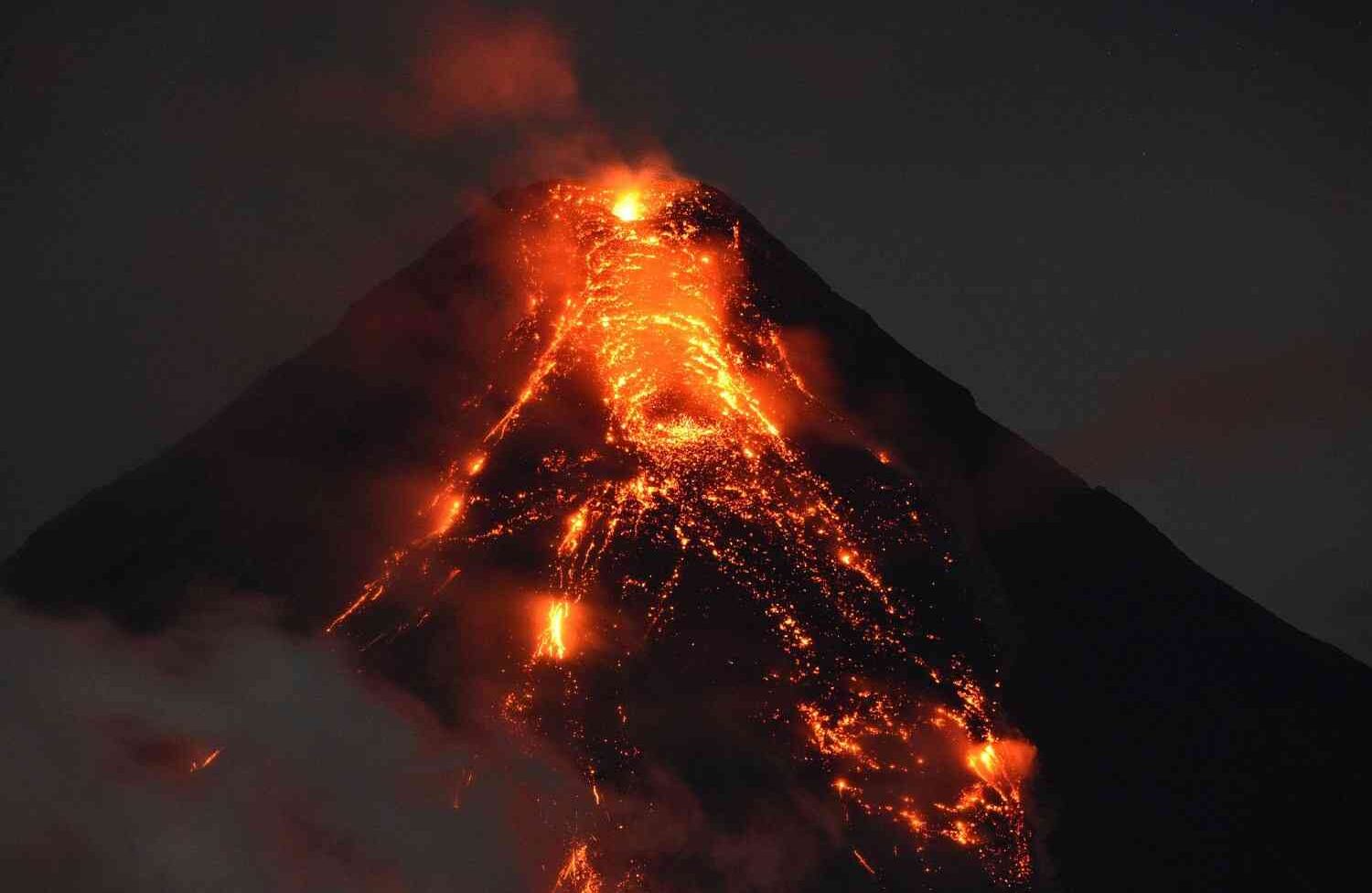 Lava fluye desde el volcán Mayon y continúa en erupción, al sur de Manila, el 25 de enero de 2018. Las autoridades filipinas declararon zona prohibida alrededor del volcán en erupción; dijeron que eliminarán a todos los retenidos, por la fuerza si es necesario, para evitar bajas luego de que decenas de miles de otros residentes huyeron a un lugar seguro. / AFP PHOTO / TED ALJIBE