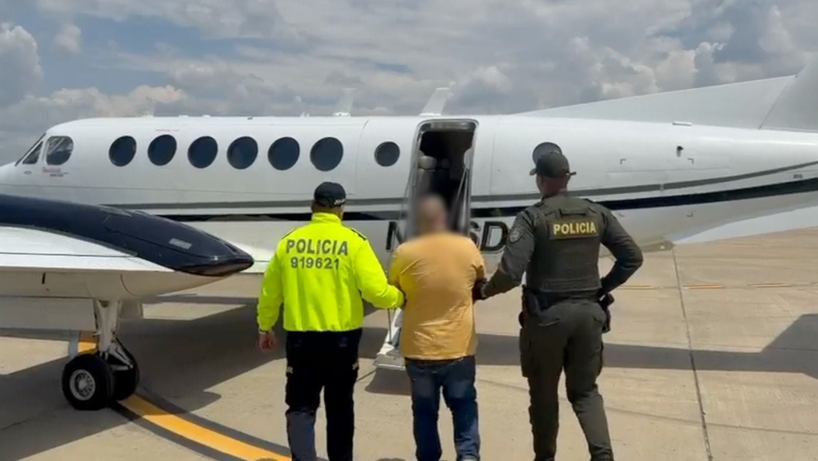 Policías acompañan al extraditable alias Rolex.