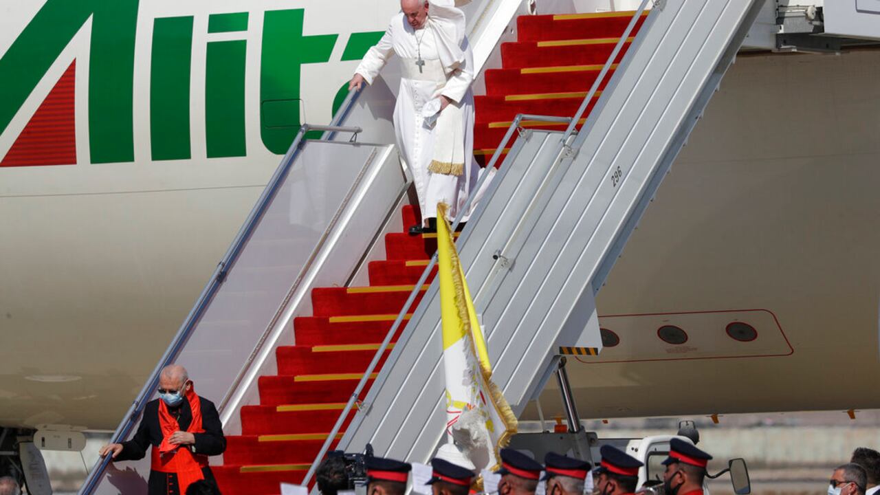 Pope Francis walks down the steps of an airplane as he arrives at Baghdad international airport, Iraq, Friday, March 5, 2021. Pope Francis is heading to Iraq to urge the country's dwindling number of Christians to stay put and help rebuild the country after years of war and persecution, brushing aside the coronavirus pandemic and security concerns. (AP Photo/Andrew Medichini)