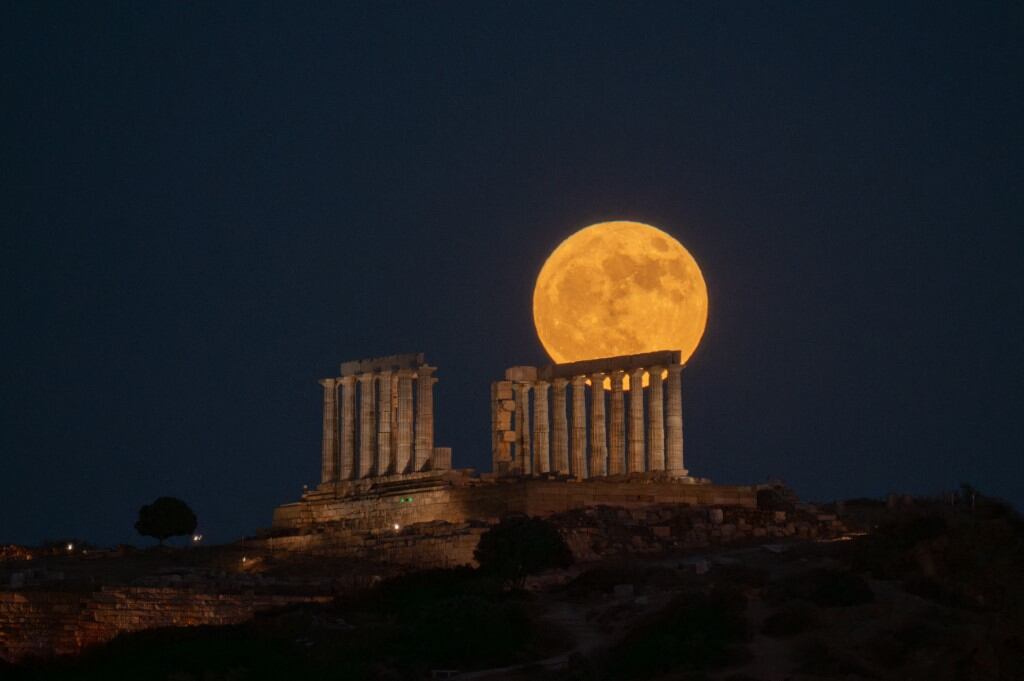 Las antiguas ruinas del Templo de Poseidón destacaron bajo una Luna de intensos tonos anaranjados.