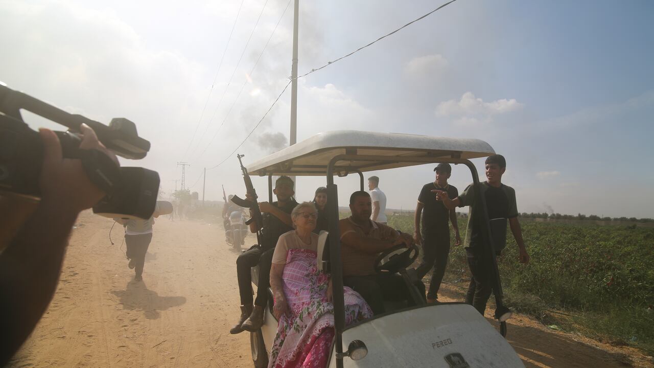 Terroristas transportan a una civil israelí capturada desde el kibutz de Kfar Azza a la Franja de Gaza el sábado 7 de octubre de 2023.