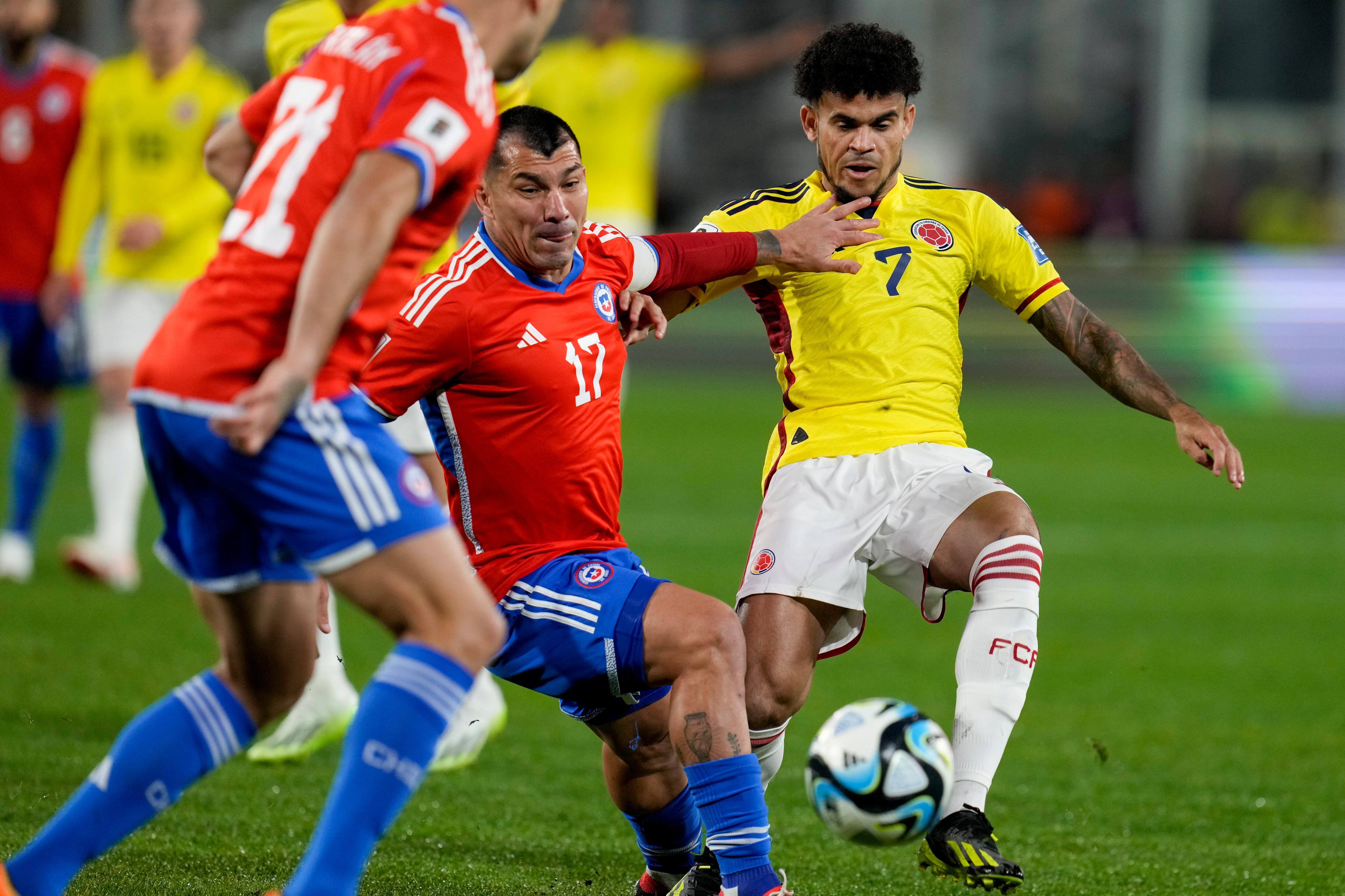 El colombiano Luis Díaz, derecha, y el chileno Gary Medel luchan por el balón durante un partido de fútbol de clasificación para la Copa Mundial de la FIFA 2026 en el estadio Monumental de Santiago, Chile, el martes 12 de septiembre de 2023. (Foto AP/Esteban Félix)