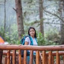 Turista caminando sobre un puente de madera ubicado en el parque natural de la ciudad de Medellín.