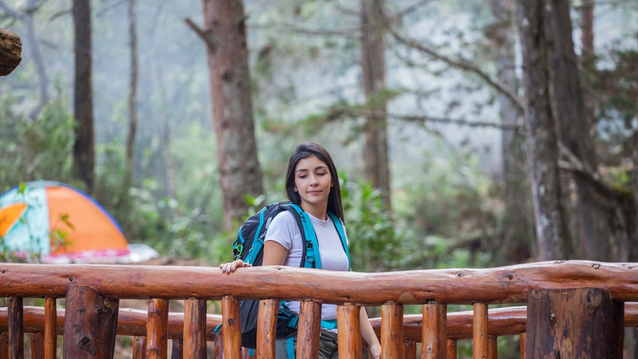 Turista caminando sobre un puente de madera ubicado en el parque natural de la ciudad de Medellín.