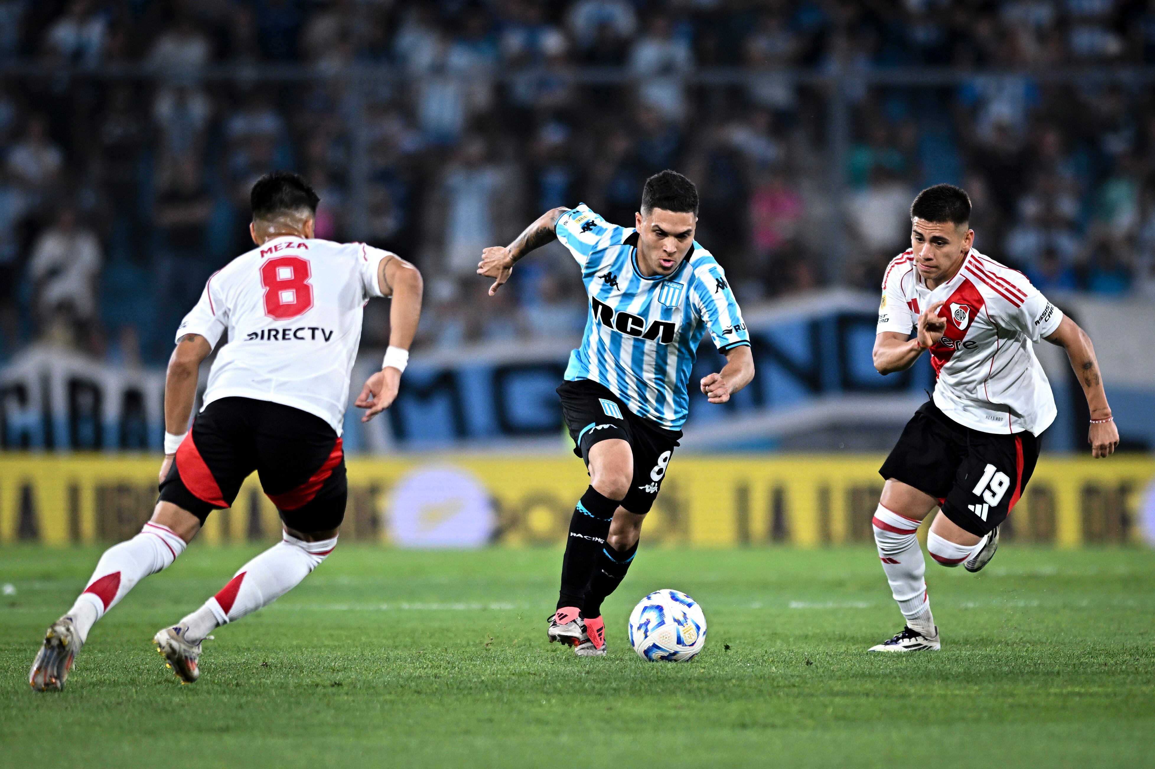 Juan Fernando Quintero de Racing Club conduce el balón ante Claudio Echeverri (d) y Maximiliano Meza (i) de River Plate durante un partido de la Liga Profesional 2024 entre Racing Club y River Plate en el estadio Presidente Perón el 14 de diciembre de 2024 en Avellaneda, Argentina.