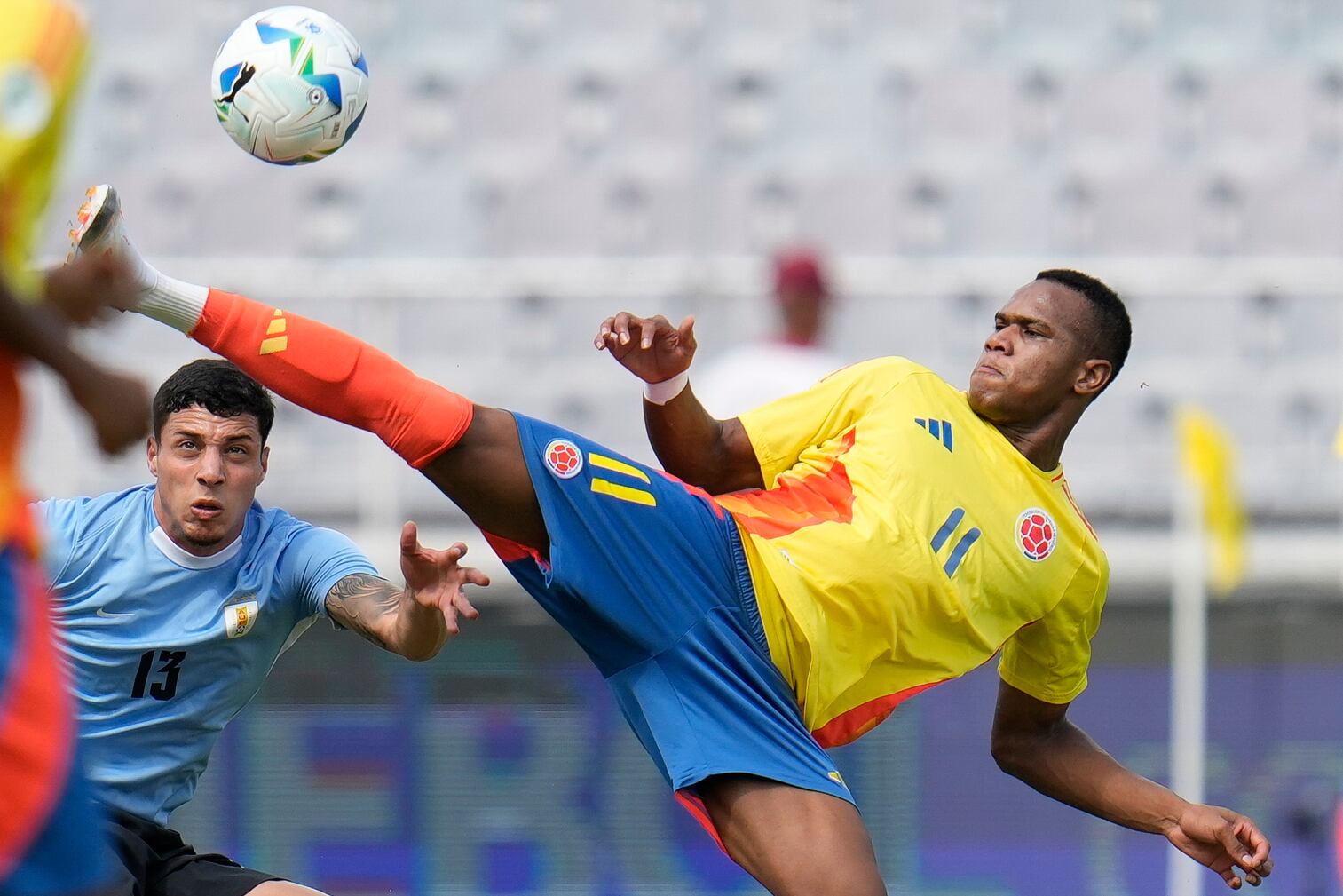 El colombiano Andy Batioja controla el balón bajo la presión del uruguayo Facundo González