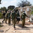 Israeli soldiers carry bodies of killed Israelis in kibbutz Kfar Azza on Tuesday, Oct. 10, 2023. Hamas militants overran Kfar Azza on Saturday, where many Israelis were killed and taken captive. (AP Photo/Ohad Zwigenberg)